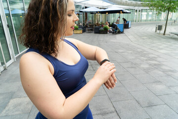 Woman and sports, exercise for weight loss in the fresh air. Happy curvy 40s woman doing workout...