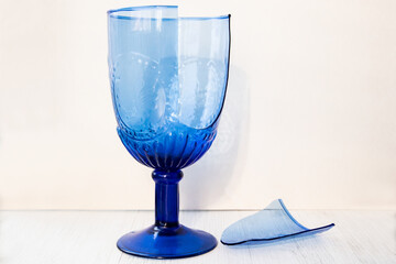 Broken blue glass on a white wooden background. Two pieces.