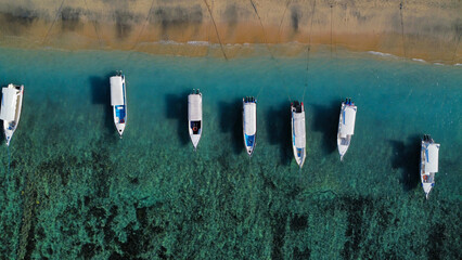 Idyllic beach in Indonesia with moored boats, seen from above