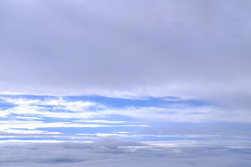 Obraz premium Looking through airplane window with dramatic cloudscape. white clouds with the blue sky from the high angle view. Cloudscape background. Nature scene.
