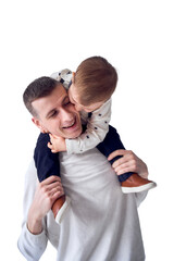  father carries his son in his arms and plays with him in a minimalist studio