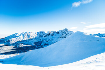 Obraz premium Tatra mountains at winter time. View of the white snow-capped peaks, frosty winter mountains. Kasprowy Wierch, High Tatra, Poland, Europe.