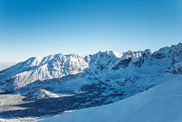 Fototapeta premium Tatra mountains at winter time. View of the white snow-capped peaks, frosty winter mountains. Kasprowy Wierch, High Tatra, Poland, Europe.