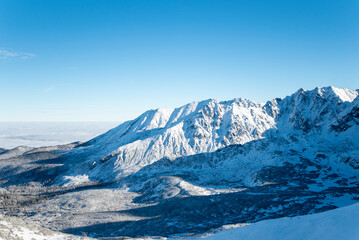Tatra mountains at winter time. View of the white snow-capped peaks, frosty winter mountains. Kasprowy Wierch, High Tatra, Poland, Europe.