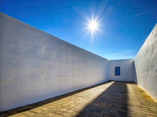 Obraz premium Minimalist architectural photography: sunlit white wall, stark shadow, hollow space, modern design.