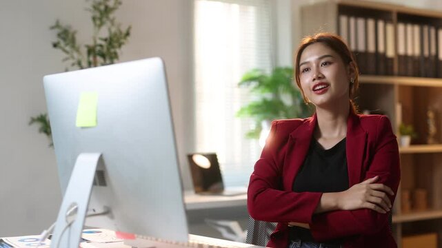 Asian businesswoman working and relaxing at office desk, enjoying a moment of relaxation in her office chair.