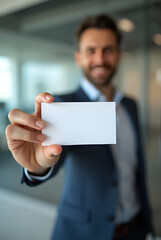 MOCKUP - blank business card held by a professional against a blurred office background