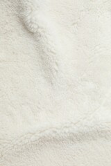 White cuddle teddy bear fabric as background, top view