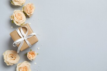 Beautiful composition with peony roses and gift box on gray background