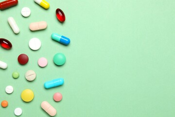 Various pills on green background