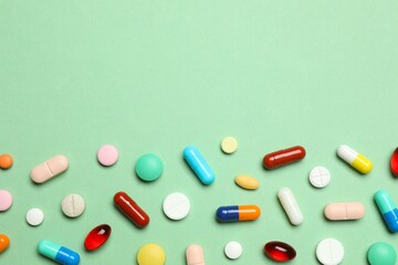 Various pills on green background