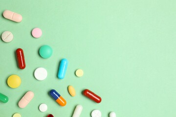 Various pills on green background