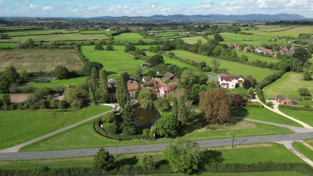 luxury property castle estate hotel surrounded by green fields england sunshine enhances real mansion circling aerial view drone uk scenic architecture historical tourism travel 