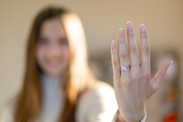 Woman Showing Engagement Ring on Hand. Close-up of a woman's hand with an elegant engagement ring,...