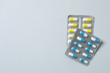 Pills in blister packs on gray background, close up
