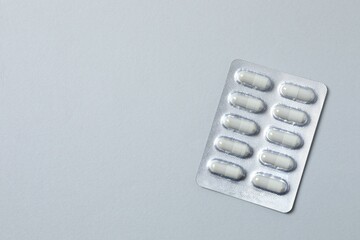 Pills in blister packs on gray background, close up