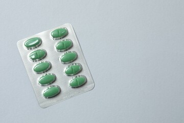 Pills in blister packs on gray background, close up