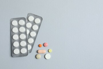 Pills in blister packs on gray background, close up