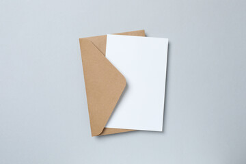 White paper card with craft envelope on gray background