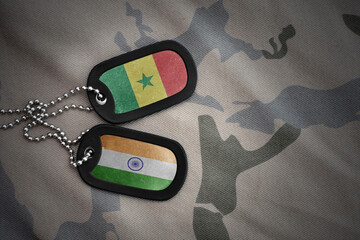 vintage army blank, dog tag with flag of senegal and india on the khaki texture background....