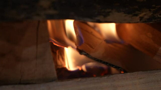 Yellow flames burning paper or book pages. Gray ash and smoke from burning letters or documents in fireplace. Remains of diary pages destroyed by flames of fire. Burning bonfire, campfire close up.