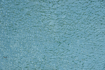 Close-up of shattered glass surface under light.