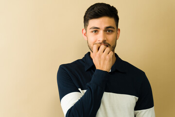 Young man biting his nails showing anxiety and stress