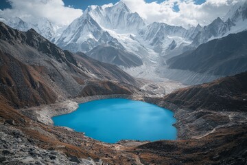 Naklejka premium Breathtaking blue lake surrounded by majestic snow capped mountains and lush greenery in nature
