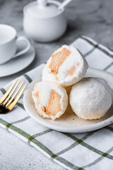 Coconut ice cream balls on white plate with cutlery