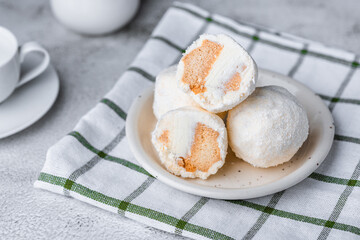Coconut ice cream balls on white plate with cutlery