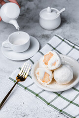Milk in a white cup and cookies on a gray background.