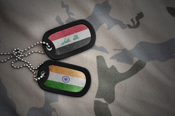 vintage army blank, dog tag with flag of iraq and india on the khaki texture background. military...