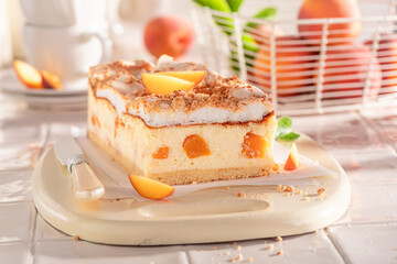 Swee and fresht cheesecake with peaches served on kitchen.