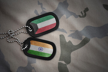 vintage army blank, dog tag with flag of kuwait and india on the khaki texture background. military concept.