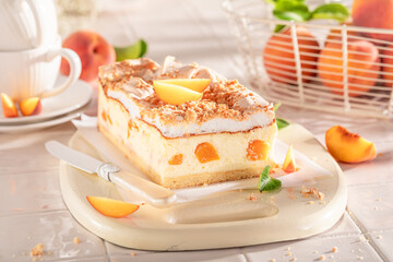 Tasty and delicious cheesecake with peaches and cocoa foam.