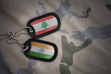vintage army blank, dog tag with flag of lebanon and india on the khaki texture background....