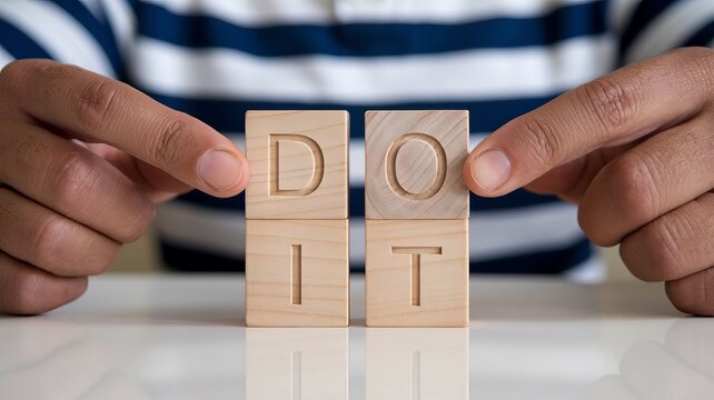 hands holding wooden blocks spelling out "DO IT".