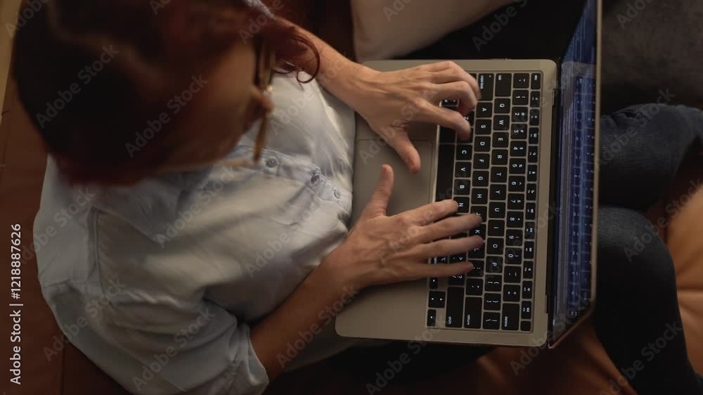 Aufkleber An individual is deeply focused and engaged while typing on a laptop in the comfortable setting of their own home, contributing to their blogging, business communications, and creativity