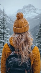 Fototapeta premium Woman in winter hat and jacket admiring snowy mountains.