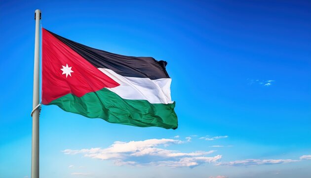 A vibrant flag of Jordan proudly waves atop a pole against an expansive blue sky