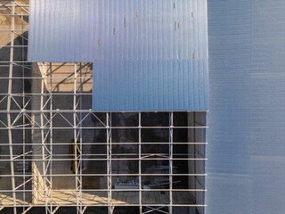 A construction site with a partially built warehouse featuring a steel framework and metal roof....