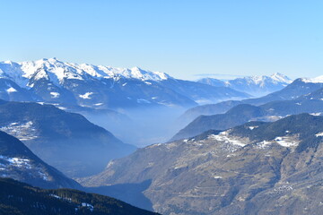 Winter scenery of French alps with tones of blue under snow and fog 