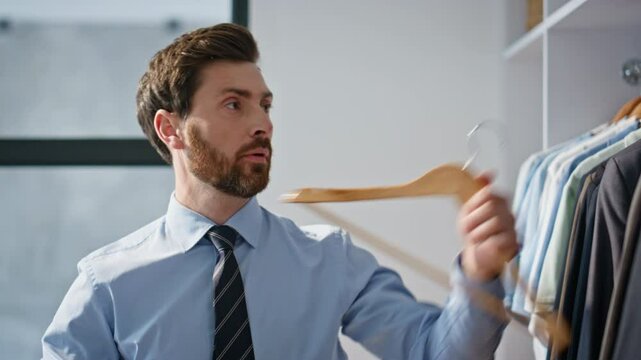 Man choosing formal suit at large wardrobe closeup. Office guy trying on blazer