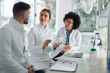 Group of  scientists communicating in laboratory. 