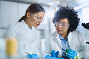 Female scientist talking while working on scientific research in laboratory.	