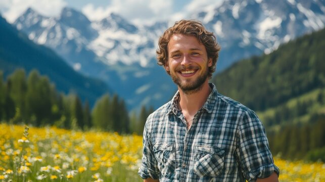 Farmer smiling in a field of flowers with mountains in the background