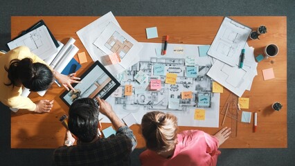 Top view of engineer working together to design building construction while standing at meeting...