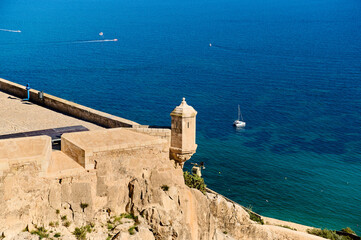 Coastal view from ancient fortress overlooking calm blue waters and distant sailboats in the...