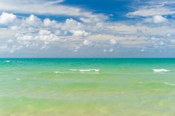 seascape landscape and skyscape background by sea beach with little waves to clear clean ocean water and nature white clouds on blue sky daylight for summer holiday travel at Sai Kaew Beach Thailand