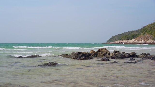 seascape landscape background by sea sand beach or island with clear water little waves and nature rocks on daylight for summer holiday travel at Sai Kaew Beach Chon Buri in Thailand in slow motion